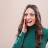 Portrait of young happy woman who is calling to someone